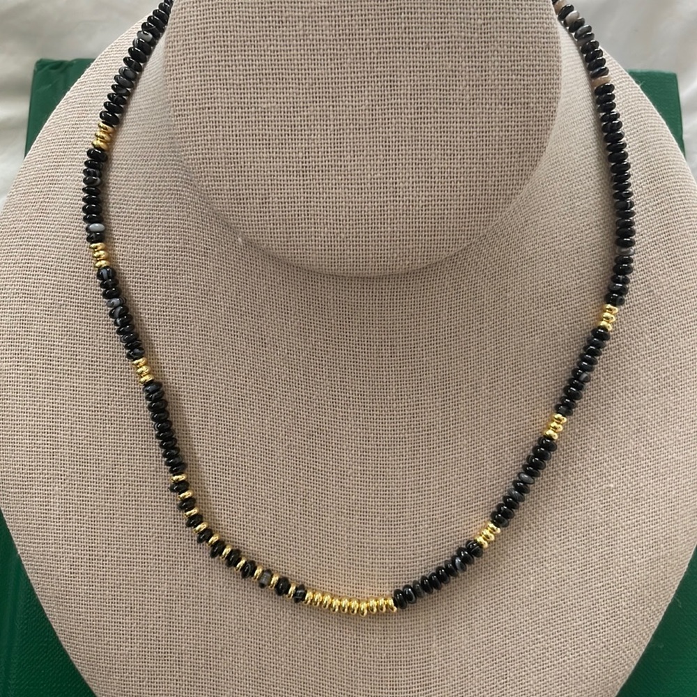 Various beaded necklaces in earth tone colors with gold beads.